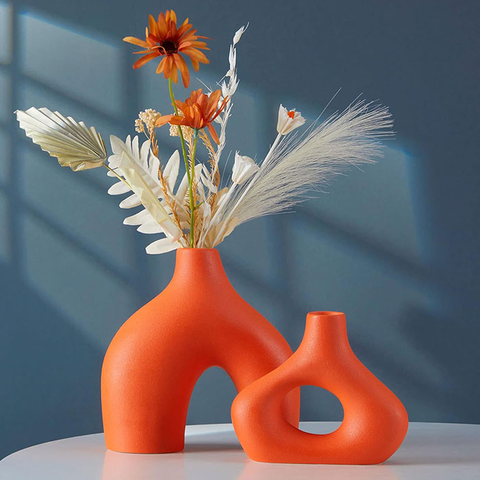 Orange vase with flowers inside 