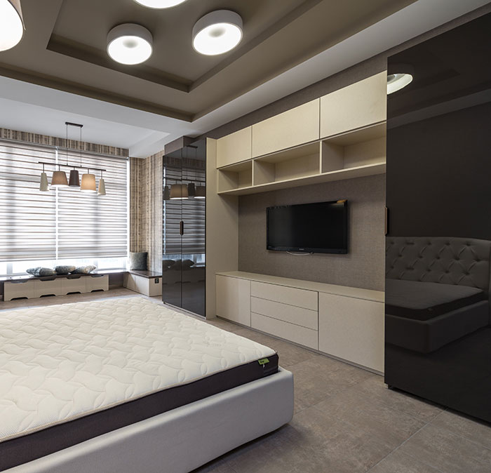 Modern bedroom with bed, TV, and a cupboard 