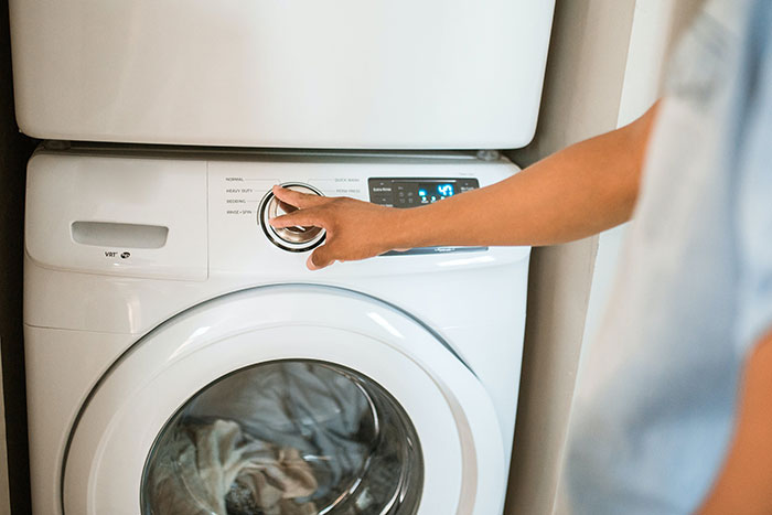 Person Doing Laundry with a white washing machine Person Doing Laundry with a white washing machine