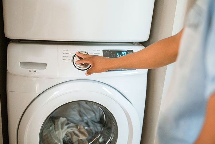 Person Doing Laundry with a white washing machine