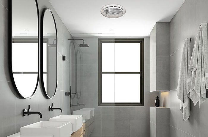 White bathroom with mirrors, a window, and bathroom fan