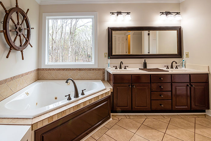 A brown spacious bathroom with cabinets A brown spacious bathroom with cabinets