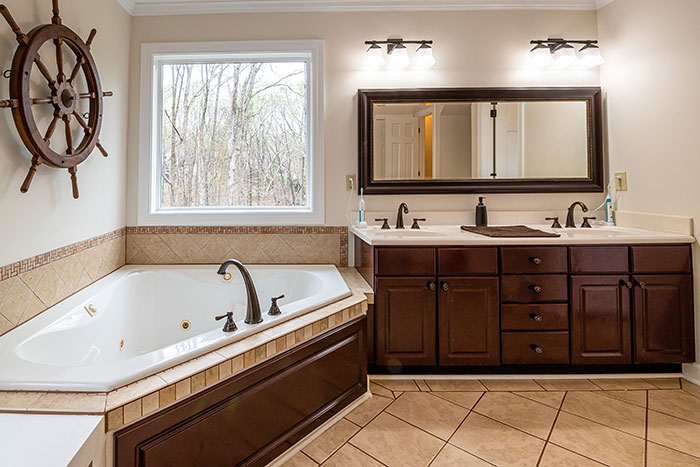 A brown spacious bathroom with cabinets 