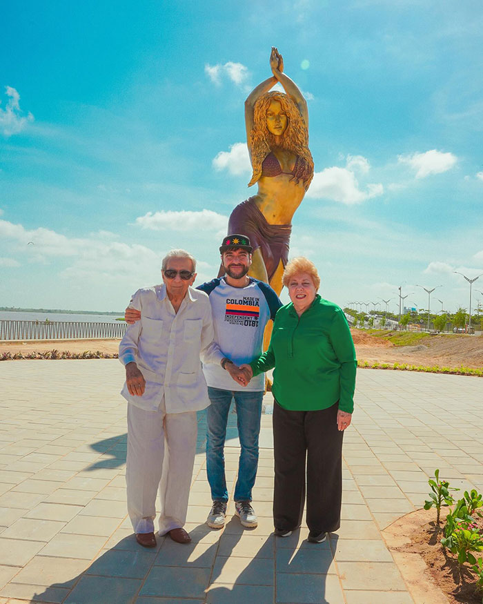 A group posing in front of a colossal Shakira statue in Colombia on a sunny day. A group posing in front of a colossal Shakira statue in Colombia on a sunny day.