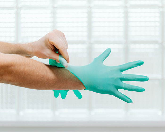 Person putting on plastic gloves
