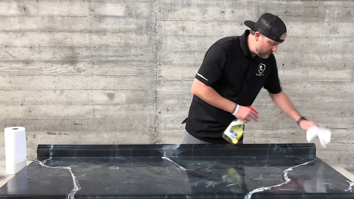 Man cleaning a black epoxy countertop