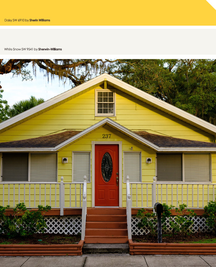 Yellow exterior house with red doors and white trim, showcasing one of the top exterior house colors to turn heads.