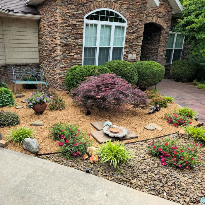 Front yard with flowers, stones, small trees