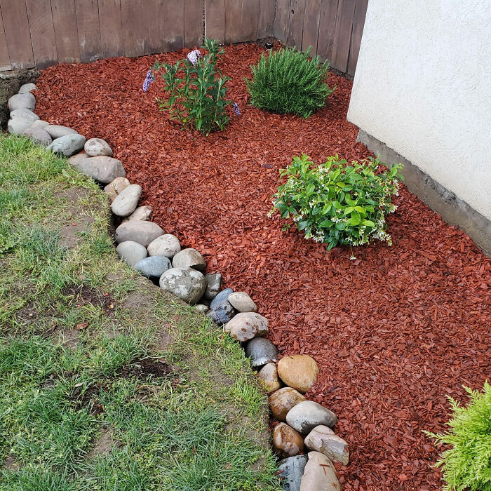 Front yard decoration with red mulch and rocks as borders