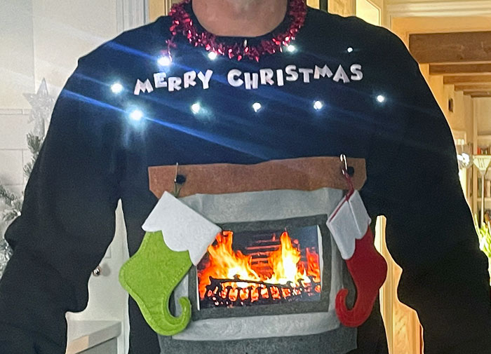 My Husband Made This For His Ugly Christmas Sweater Day At Work. That's An iPad Playing The Fireplace From Netflix In His Sweater