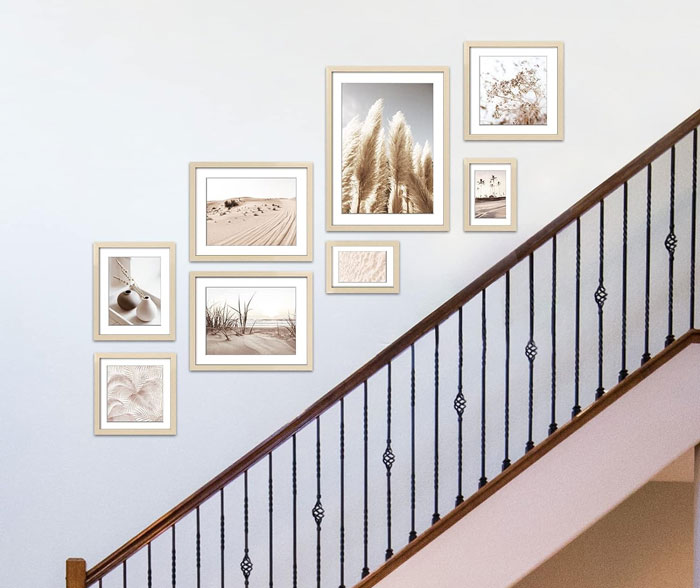 Photographs hanging on the wall above the stairs.