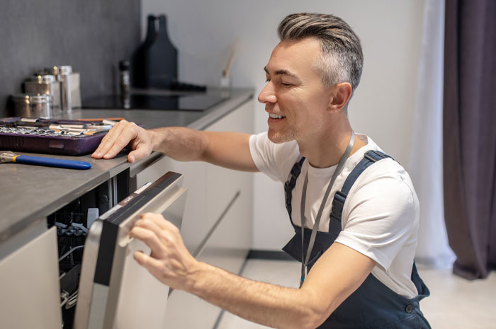 A man sitting on his haunches and examining a granite countertop A man sitting on his haunches and examining a granite countertop