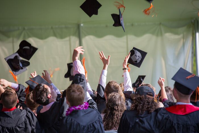 People throwing hats in the air at a graduation ceremony