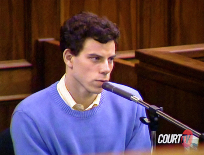 Person in court testifying, wearing a blue sweater, representing Menendez brothers' freedom case. Person in court testifying, wearing a blue sweater, representing Menendez brothers' freedom case.