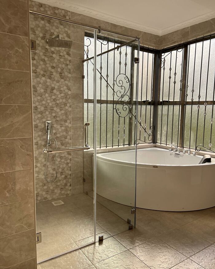 Corner walk in shower with a corner tub near a window