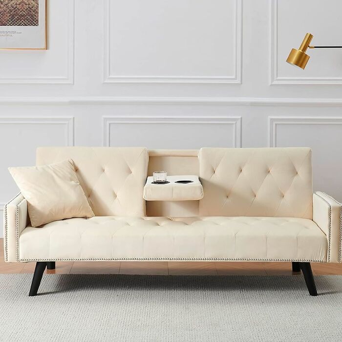 White sofa with black legs and drink holder