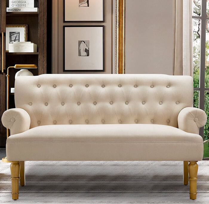 White couch with decorated wooden legs