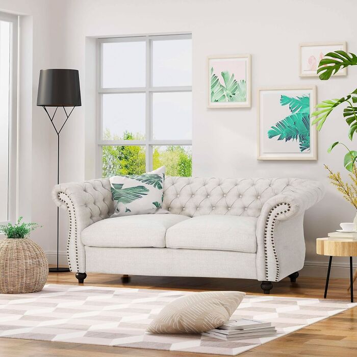 White couch with black legs and pillow