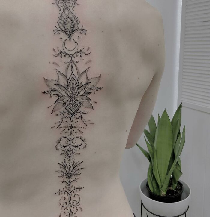 Ornamental lotus tattoo on spine