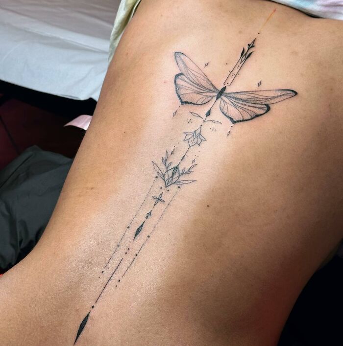 Butterfly and ornaments tattoo on spine