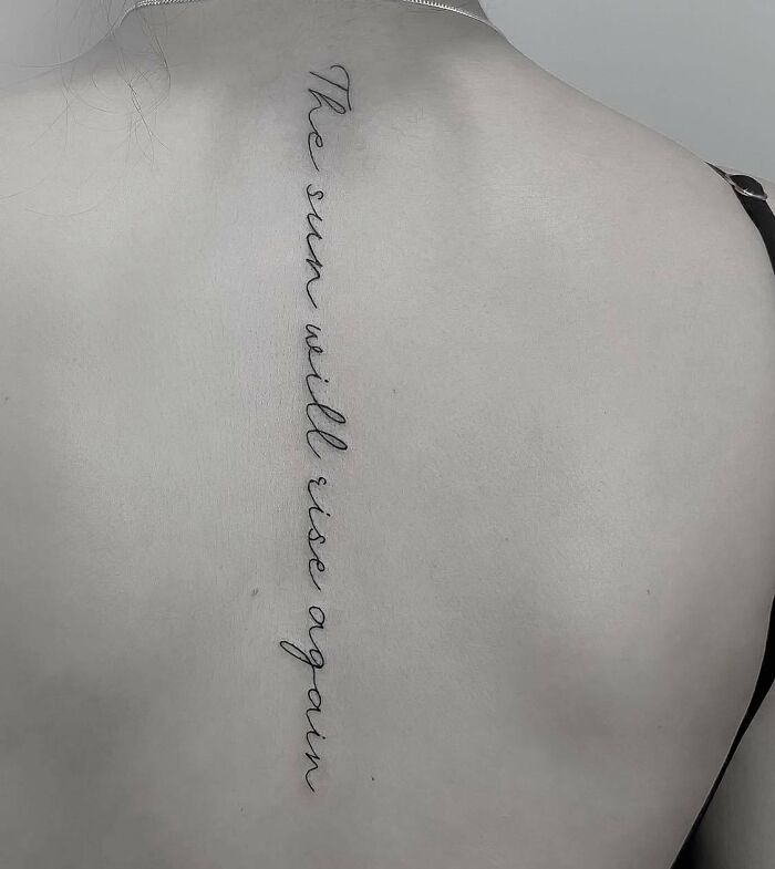 Black lettering tattoo on spine