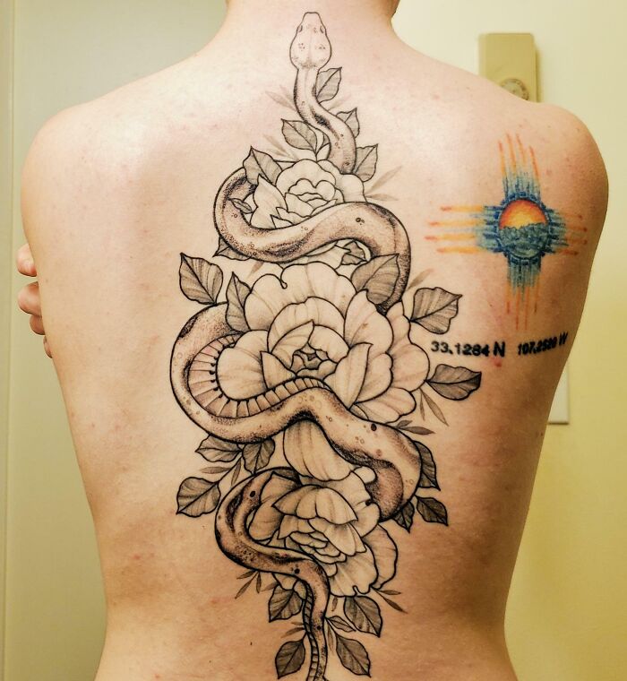Large snake and flowers tattoo on back