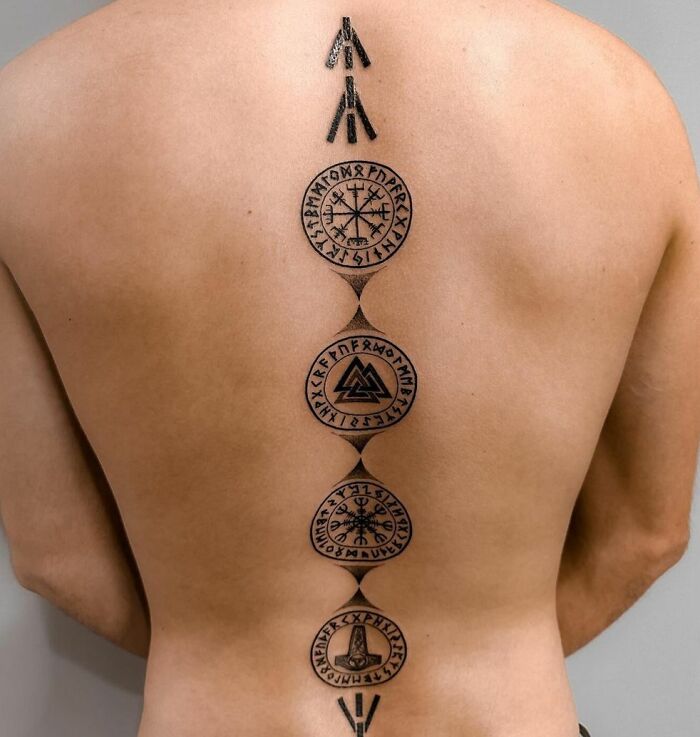 Runes themed black spine tattoo