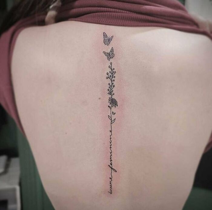 Lettering and flowers with two butterflies tattoo on spine