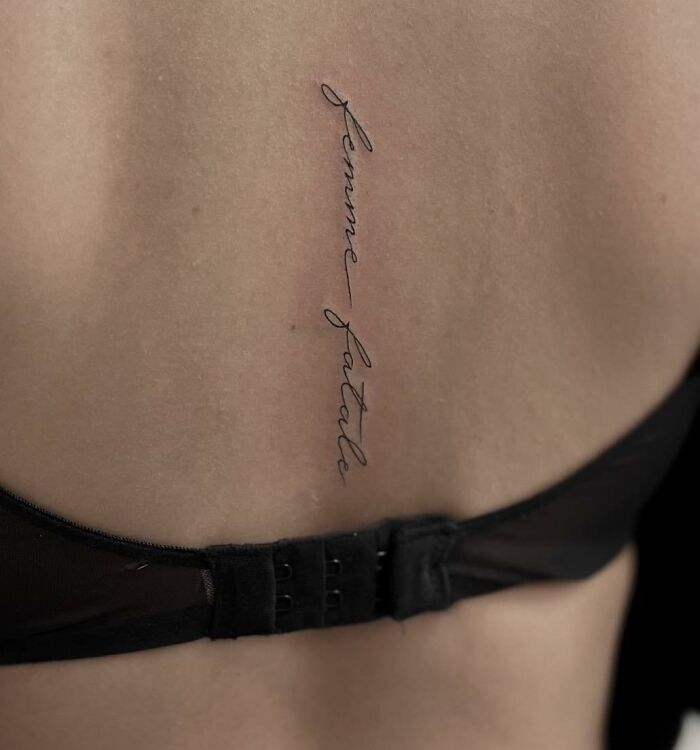 Minimal elegant lettering tattoo on spine