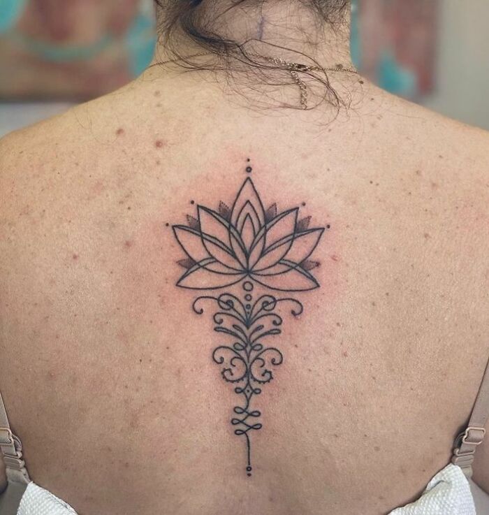 Black linear lotus with ornaments tattoo on back