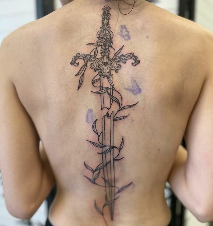 Broken sword and vine tattoo on back