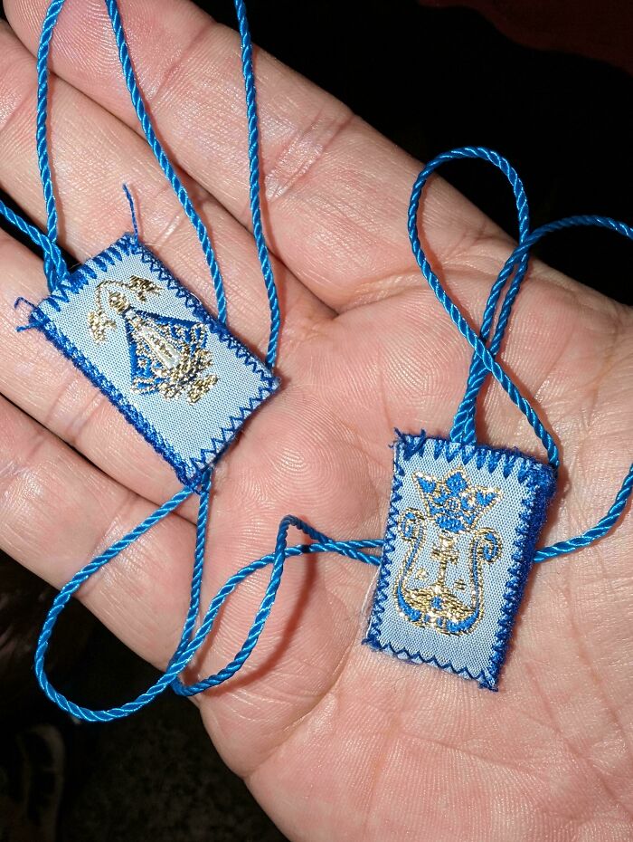 Two Small Fabric Tags Connected By A Continuous Loop Of String. Embroidery Likely Related To Roman Catholic Church. Found Wrapped Around Cash