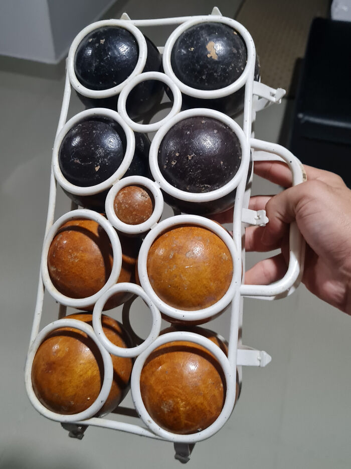 Conjunto de 9 bolas de madera. 4 bolas negras, 4 marrones y una bola marrón más pequeña