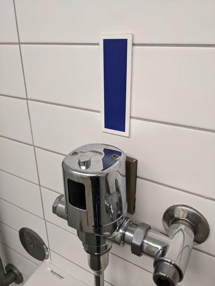 Solid State White Rectangle With Blue Center Fixed To The Wall Above A Urinal In A Multi Sports Complex. No Scent, No Electronics. What Is This Thing?