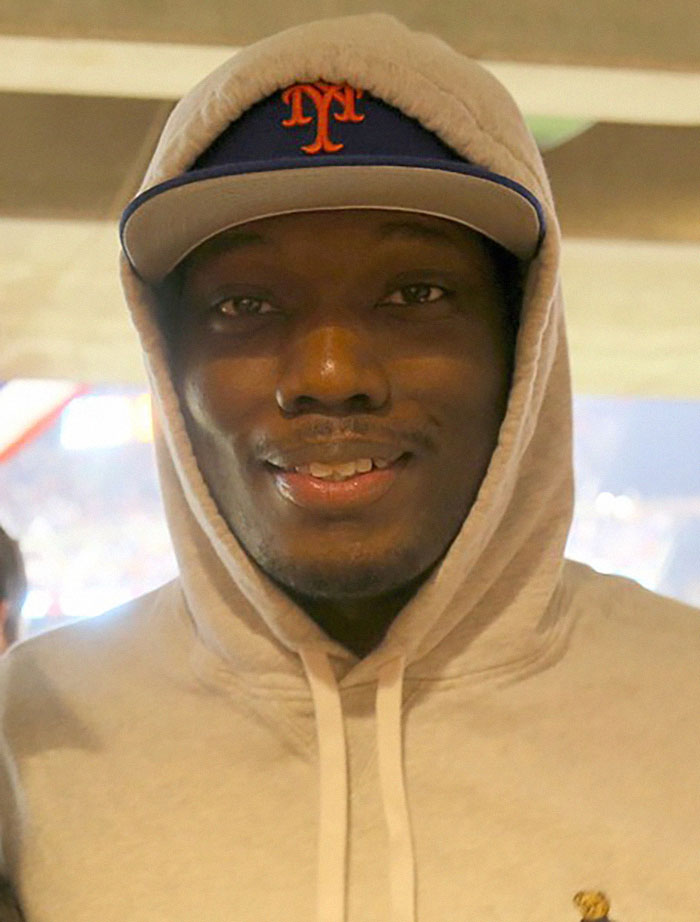 A person smiling while wearing a hoodie and a Mets cap, celebrating a response. A person smiling while wearing a hoodie and a Mets cap, celebrating a response.