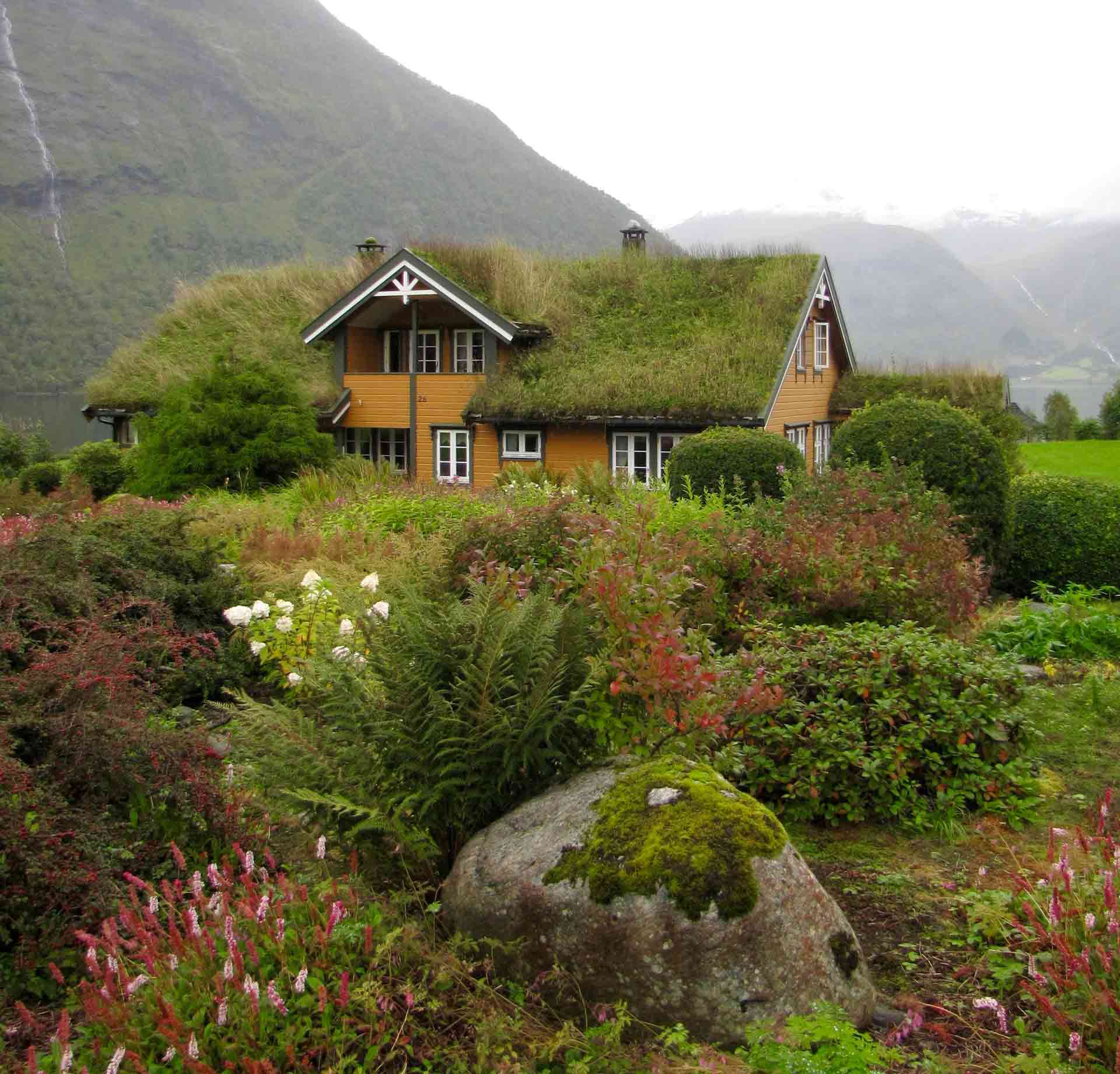 House with grass roof near mountains