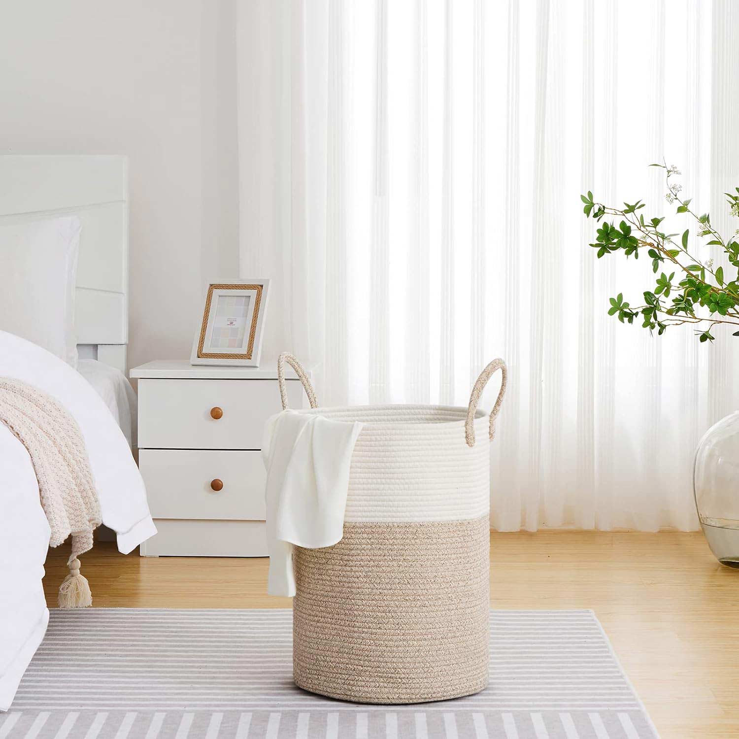 Light laundry basket on a carpet near the bed Light laundry basket on a carpet near the bed