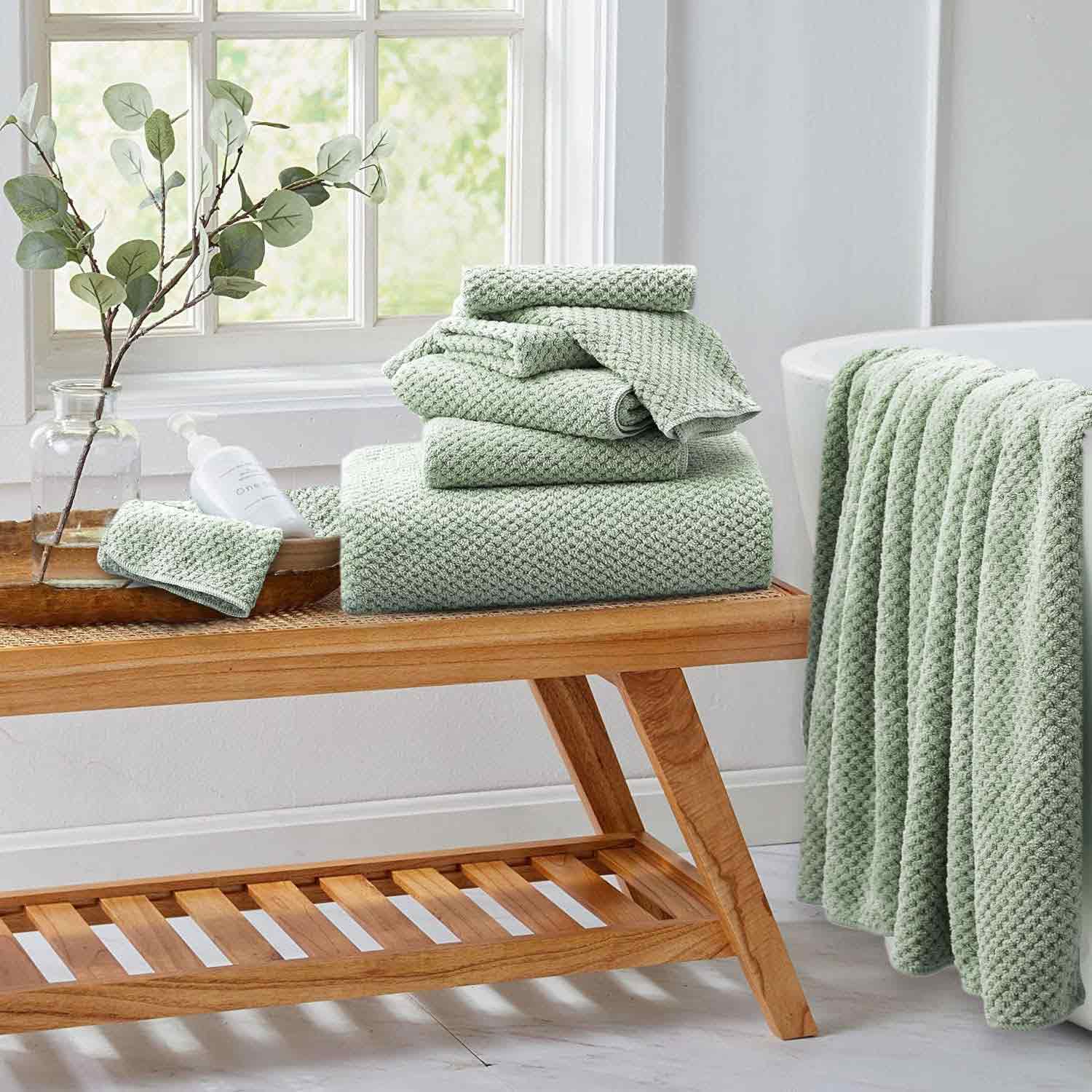 Green plush towels on a wooden low table