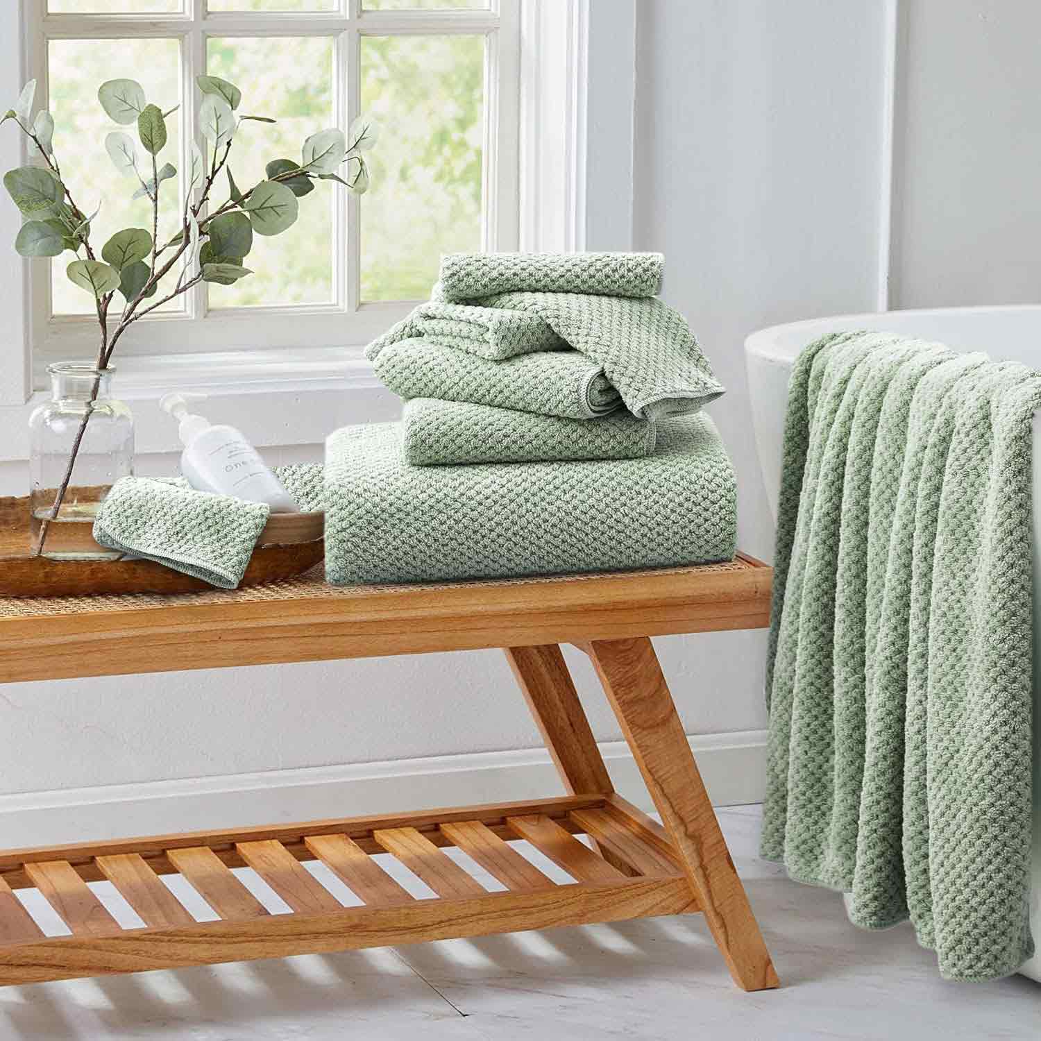 Green plush towels on a wooden low table Green plush towels on a wooden low table
