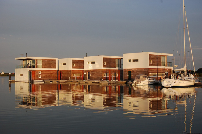 four modern boat houses on the water