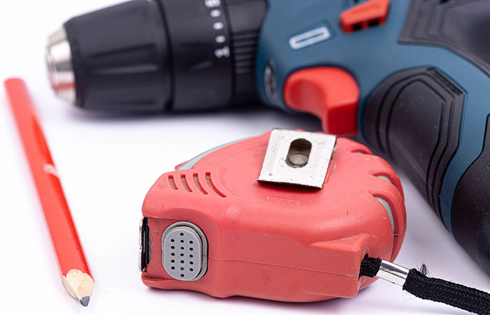 Drill, measuring tape and pencil Drill, measuring tape and pencil