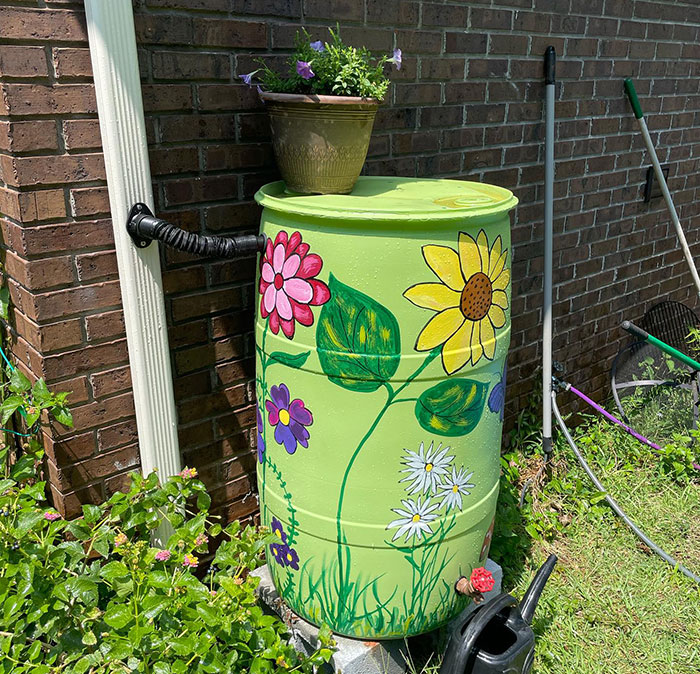 Colored and pretty green rain barrel near a wall Colored and pretty green rain barrel near a wall