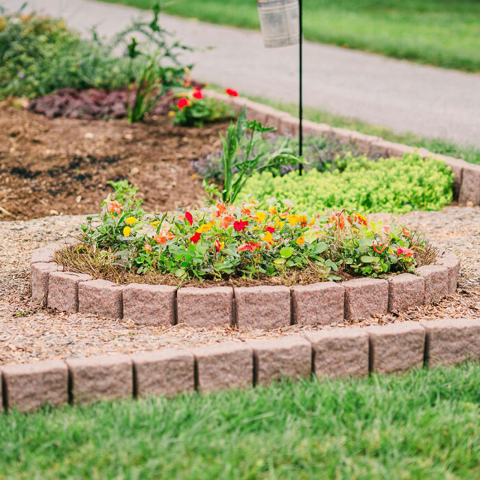 Picture of brick flower bed edging with colorful red and yellow flowers