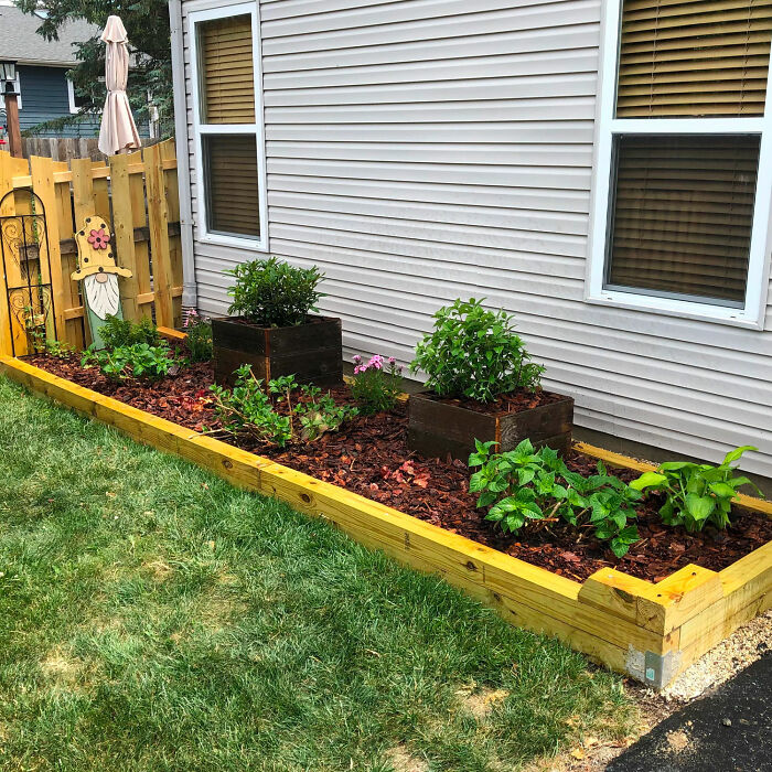 Wooden flower bed edging with flowers