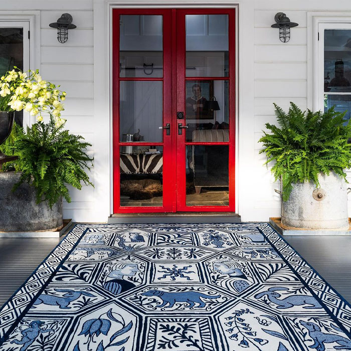House entrance with blue patterned rug and red doors