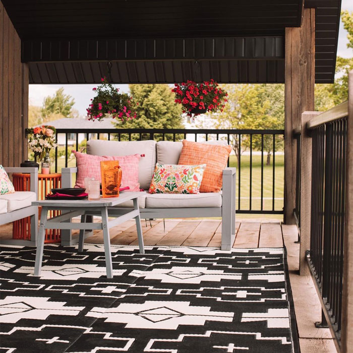 Porch with furnitures and black patterned rug