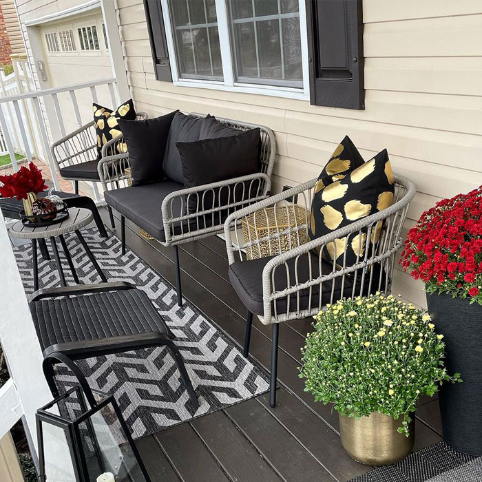 Porch with furnitures, flowers in pots and pillows