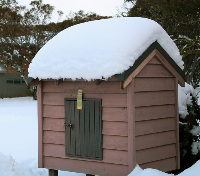 A snow covered dog box
