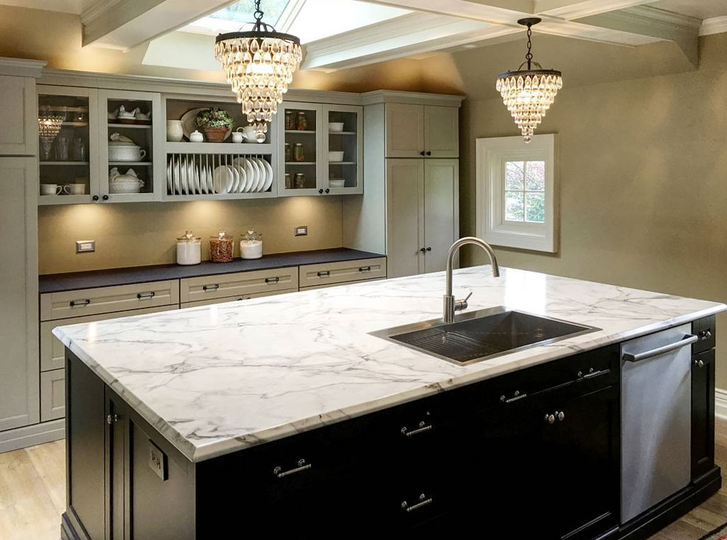 Kitchen with light marble laminate countertop and two chandeliers