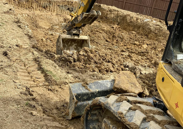 Person digging a hole size of a pool Person digging a hole size of a pool